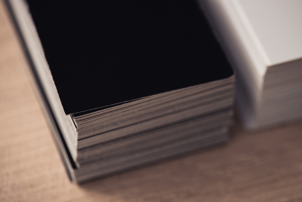 selective focus of black and white business cards stacked on wooden surface - Foto, Bild