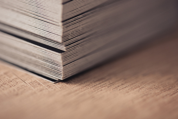 selective focus of business cards stacked on wooden surface - Foto, afbeelding