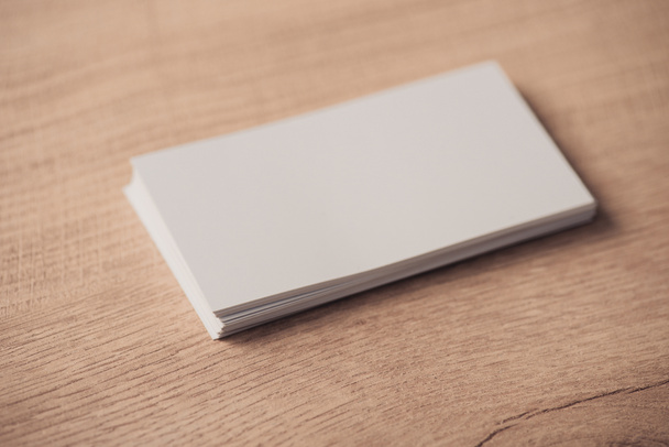 white empty business cards stacked on wooden textured surface - Foto, Imagen
