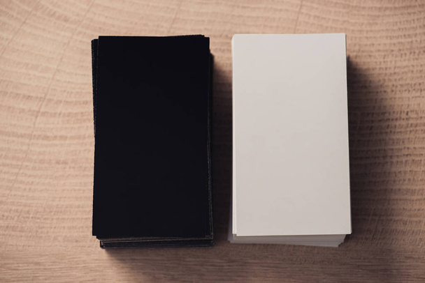 top view of white and black empty business cards stacked on wooden surface - Valokuva, kuva