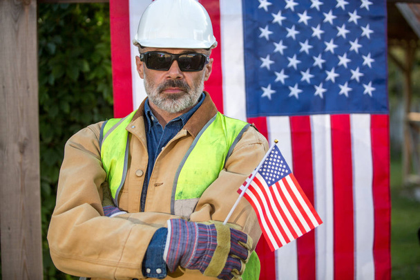A serious worker man and american flag - Foto, immagini