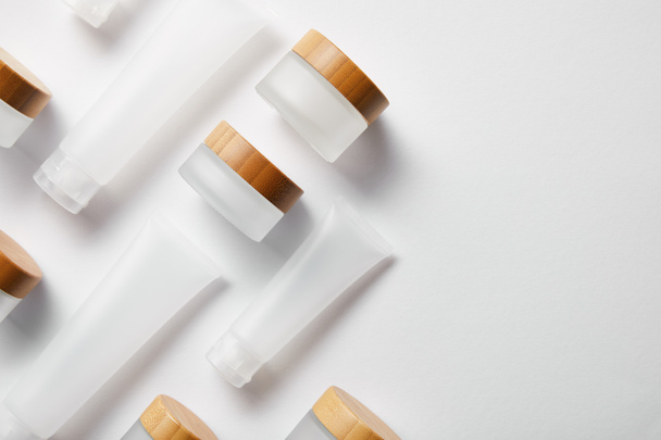 flat lay of cream tubes and jars with wooden caps on white  - Photo, Image