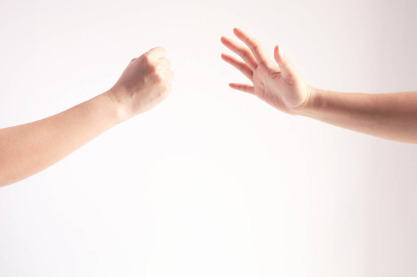 Dvě osoby hrající na papír; jednou rukou se symbolem skály nebo kladiva a jinou rukou zobrazující symbol papíru; Koncepce hospodářské soutěže. - Fotografie, Obrázek