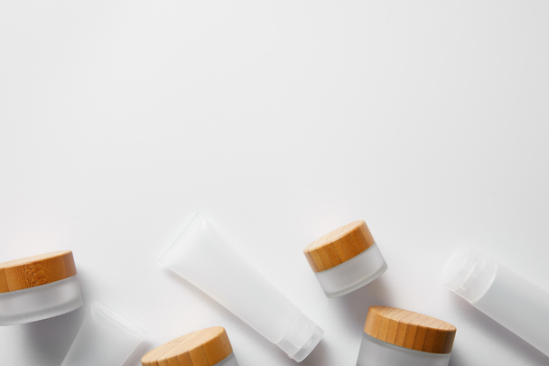 top view of few empty jars and cream tubes on white  - Fotografie, Obrázek