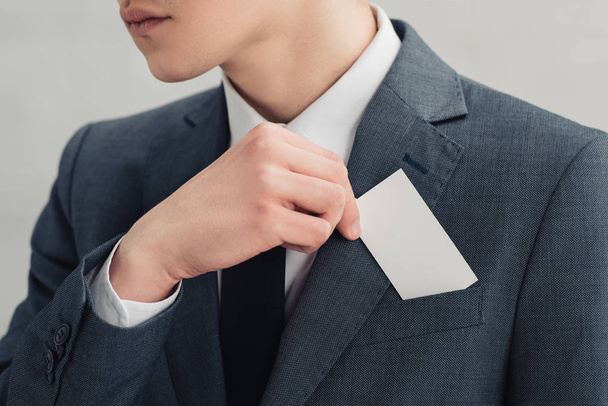 空白の名刺を持つスーツを着たビジネスマンのトリミングショット - 写真・画像