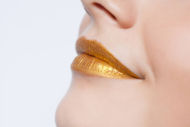 Beautiful closeup female lips with gold color makeup - Zdjęcie, obraz