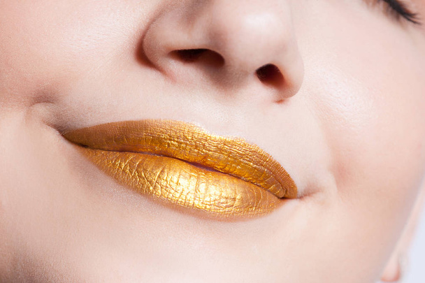 Beautiful closeup female lips with gold color makeup - Valokuva, kuva