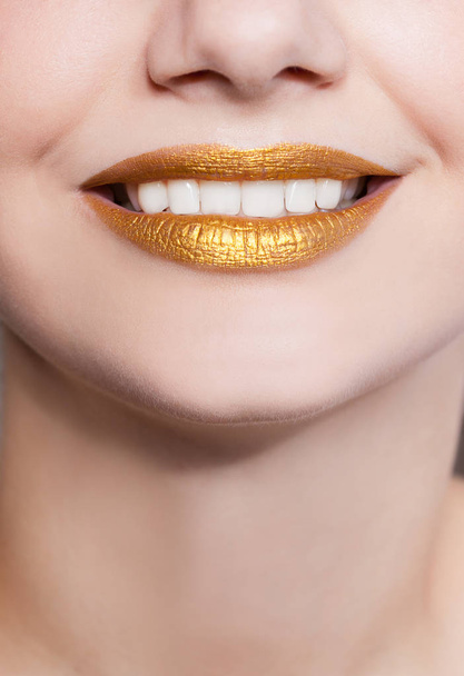 Beautiful closeup female lips with gold color makeup - Φωτογραφία, εικόνα