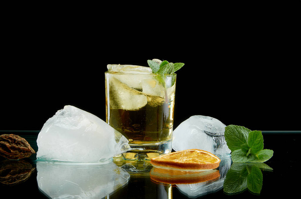 Chilled alcoholic cocktail with ice orange and fresh herbs on black background - Foto, Imagem