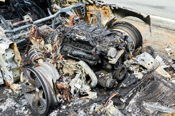 Coche completamente quemado en carretera después de la colisión con camión pesado
 - Foto, imagen
