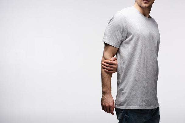 bijgesneden beeld van de man Holding hand achter rug geïsoleerd op grijs, menselijke emotie en expressie concept - Foto, afbeelding
