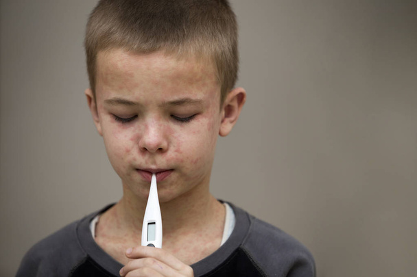 Портрет хворого сумного хлопчика з термометром, що має гарячку
 - Фото, зображення