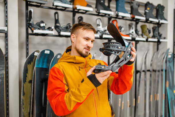 Hombre eligiendo la sujeción de botas de esquí, compras en la tienda de deportes. Temporada de invierno estilo de vida extremo, tienda de ocio activo, compra de equipos de esquí al cliente
 - Foto, imagen