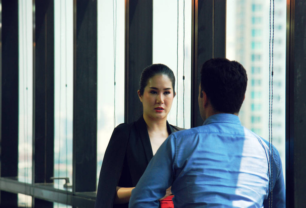 Business woman talking with business man in office and office  building background in the capital city. - Foto, Bild