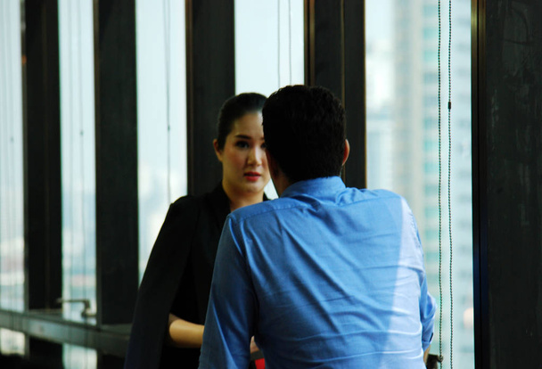 Business woman talking with business man in office and office  building background in the capital city. - Foto, Bild
