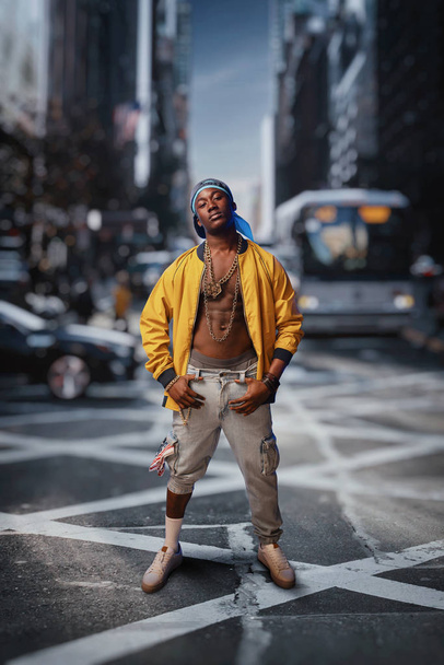 Afrikai rapper az utcán, városkép a háttérben. Rap előadóművész a városban, Underground zene életmód, a városi stílus zenész - Fotó, kép