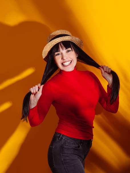 女の子帽子太陽光影熱帯黄色オレンジ若い女性の背景赤いドレス熱帯 - 写真・画像