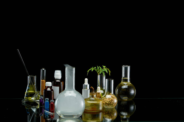 Medical jars with reagents and plant on a black background - Φωτογραφία, εικόνα