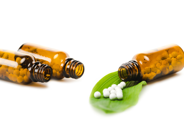 селективный фокус бутылок с лекарством вблизи зеленого свежего листа, изолированного на белом
  - Фото, изображение
