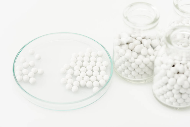 selektiver Fokus von Flaschen mit Medikamenten in der Nähe von Petrischalen isoliert auf Weiß  - Foto, Bild