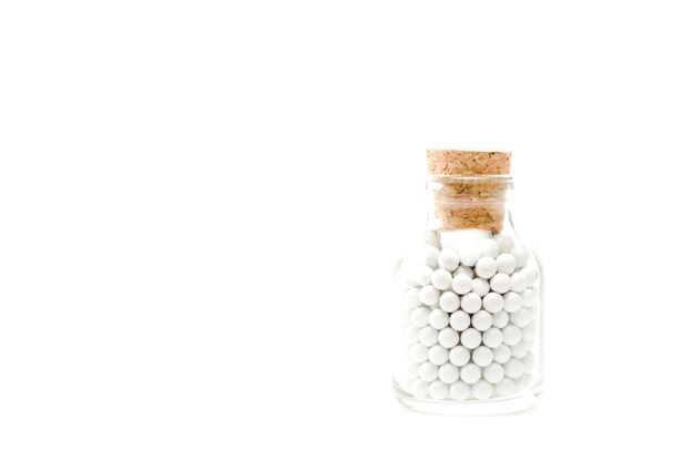 píldoras pequeñas redondas en botella de vidrio con corcho de madera aislado en blanco
  - Foto, Imagen