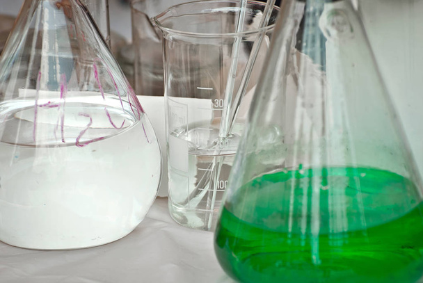 多色の液体が付いているガラス管。学校科学展における化学と生物学の実験の実証. - 写真・画像