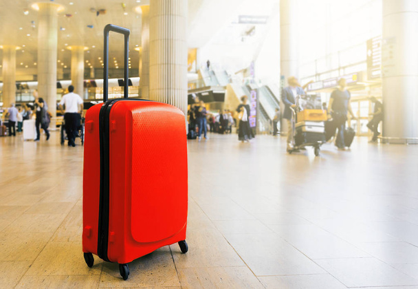 Kufřík na letištní letištní odbavovací ploše se salonkem jako pozadí. Cestovní zavazadla v letištním terminálu. Koncept motivu dovolené. Obrázek je s prostorem pro kopírování - Fotografie, Obrázek