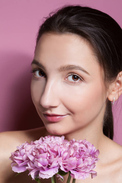Young beautiful woman with flower on pink background.  - Photo, image