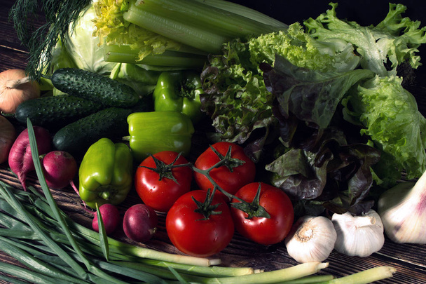 set of fresh vegetables in the dark. vegetarian food on wooden background. vegetable harvest from the garden. - Foto, Imagen
