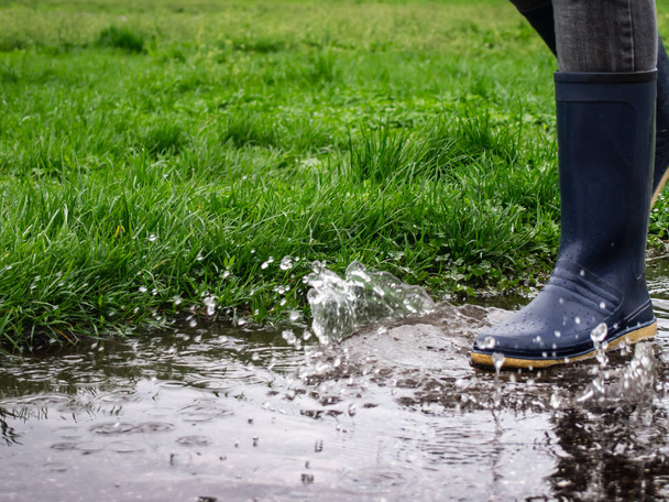 Girl in rubber boots jumping into a puddle. - Photo, Image