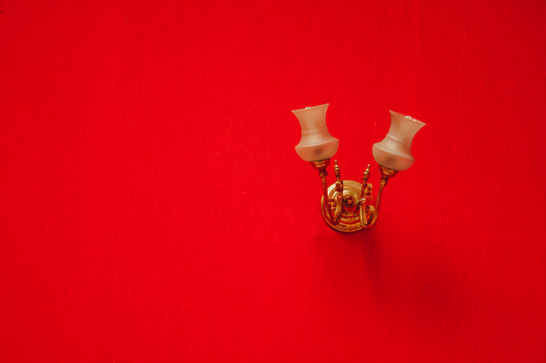 wall lamp, sconce hanging on the wall with red wallpaper. texture for the background. copy space - Foto, Imagen