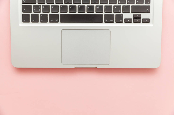 Computador portátil teclado isolado no fundo da mesa pastel rosa. Tecnologia da informação moderna e avanços sofware
 - Foto, Imagem