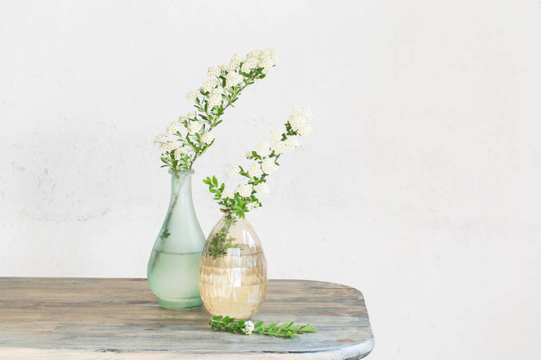 Spirea branches in vases on  vintage background of old wall - Valokuva, kuva