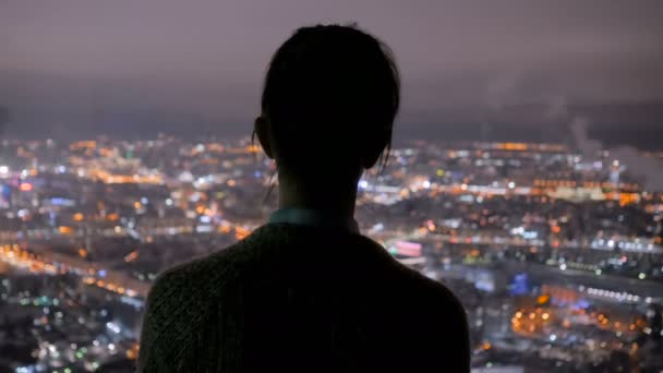 Pensive nő nézi éjszakai város felhőkarcoló - Felvétel, videó
