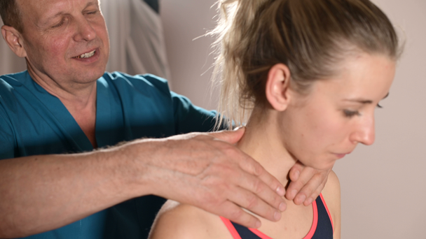 Mężczyzna ręczny masażysta terapeuta trzewnej traktuje młodych kobiet pacjenta. Rozgrzać ramiona i szyję - Materiał filmowy, wideo