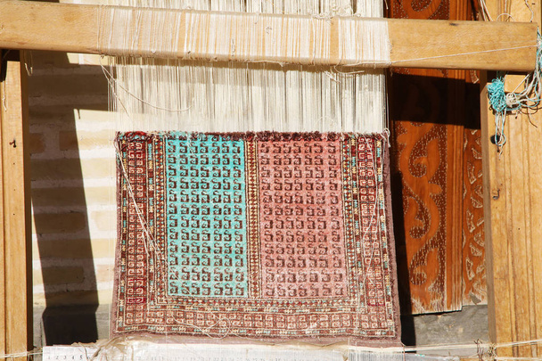 Kis szövőszék szövik a szőnyeget a Bukhara, Üzbegisztán - Fotó, kép