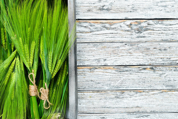 Green rye in a wooden box. On a wooden background. Top view. Free space for your text. - Foto, Bild