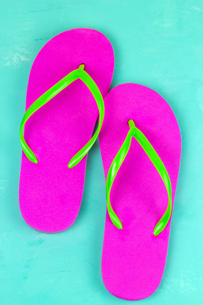 Top View Bright Pink slippers op een blauwe achtergrond - Foto, afbeelding