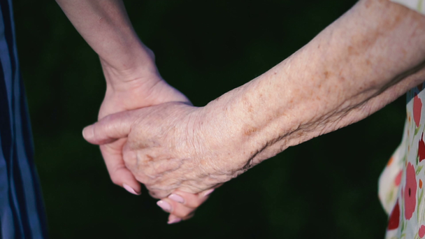 Käsivarret. Isoäidin vanhat kädet vievät nuoret naisen kädet.
 - Materiaali, video
