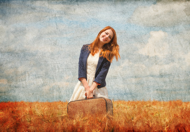 Redhead girl with suitcase at spring wheat field. - Foto, Imagem