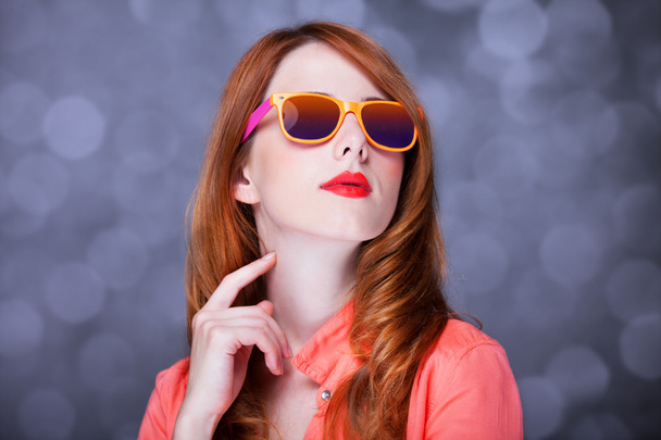 Удивлённая рыжая девушка в солнечных очках
 - Фото, изображение
