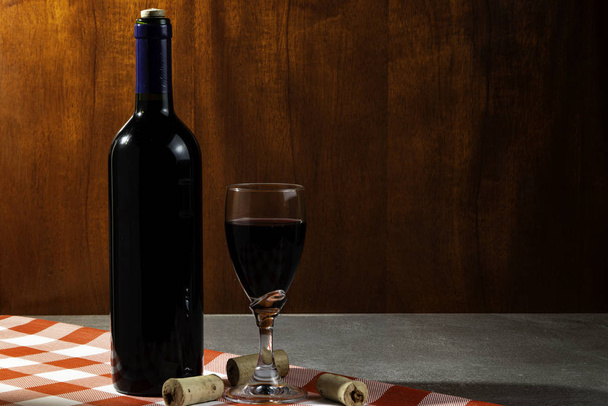 Tatmak için şarap mahzeninde bir şişe kırmızı şarap. Kırmızı ahşap arka plan. Şarap geleneği ve kültür konsepti. - Fotoğraf, Görsel