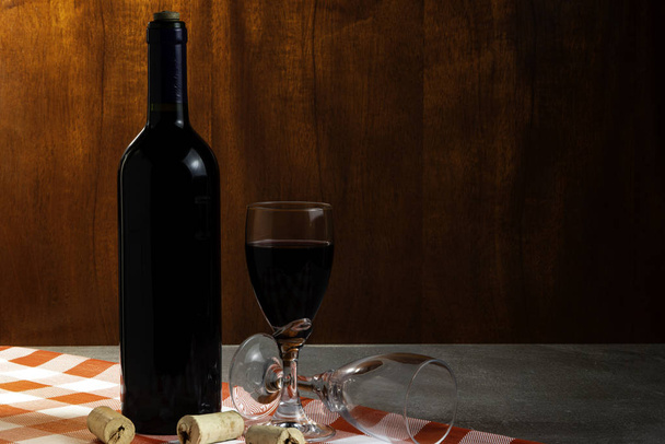 Botella de vino tinto en bodega para degustación. Fondo de madera roja. Concepto de tradición y cultura del vino
. - Foto, Imagen
