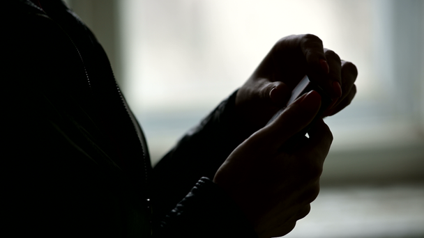 Close-up of the silhouette of female hands opening a pack of cigarettes and getting a cigarette from there. The grim concept of the harm of smoking in a low key - Footage, Video