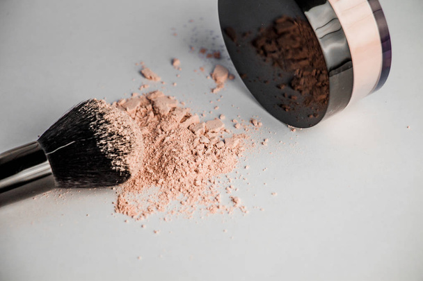 powder hill, black makeup brush, a jar of powder lying on the edge - 写真・画像