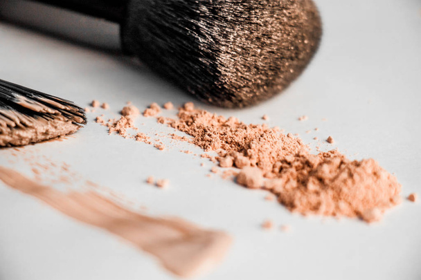 powder slide, a touch of foundation and two black makeup brushes - Fotoğraf, Görsel