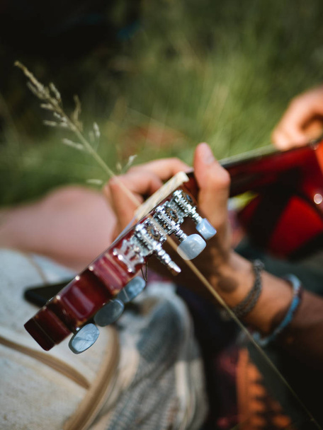 Hands playing a spanish guitar outdoors - 写真・画像