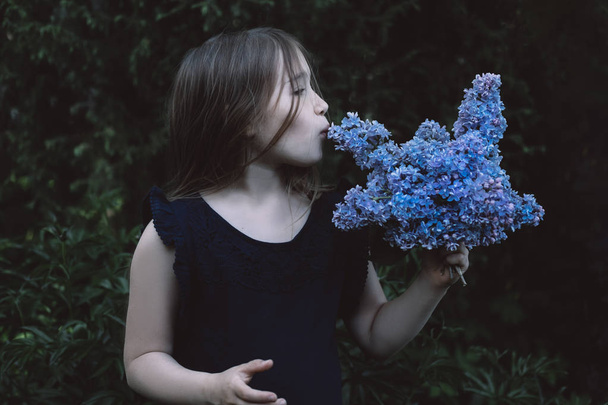 Cute little girl kissing lilac - Fotoğraf, Görsel