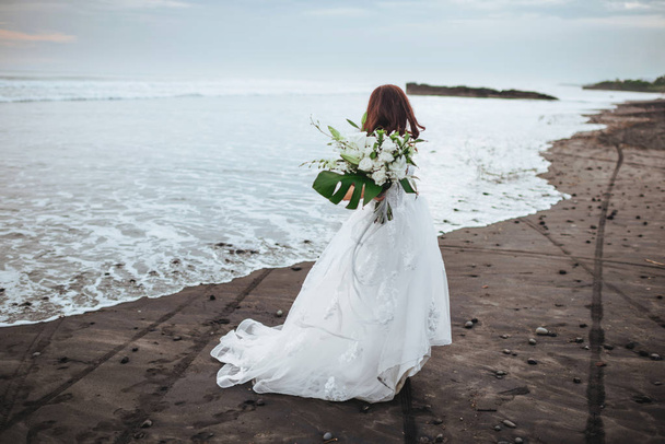 Bride on a beach in the blue water - Фото, изображение