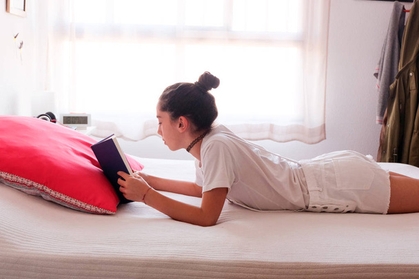 Jeune fille lisant un livre dans son lit
 - Photo, image